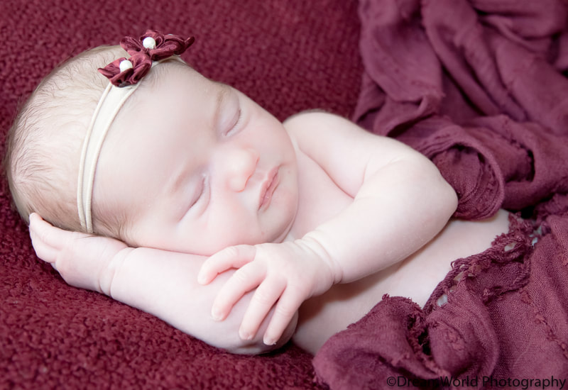Sleeping baby posed with arm underneath head
