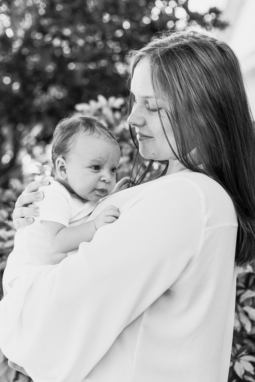 Black and white close up of mom holding baby against chest, lifestyle newborn photography, outdoors, Bradenton, FL