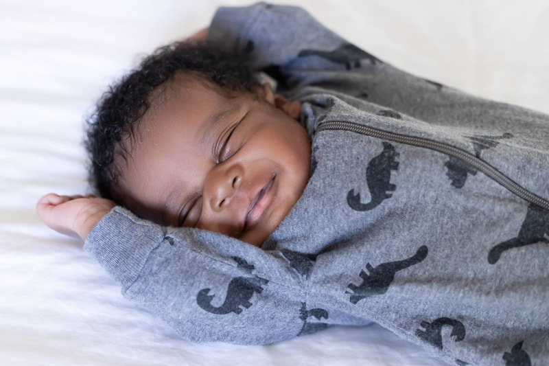 Newborn baby stretched on bed smiling, Bradenton, Florida
