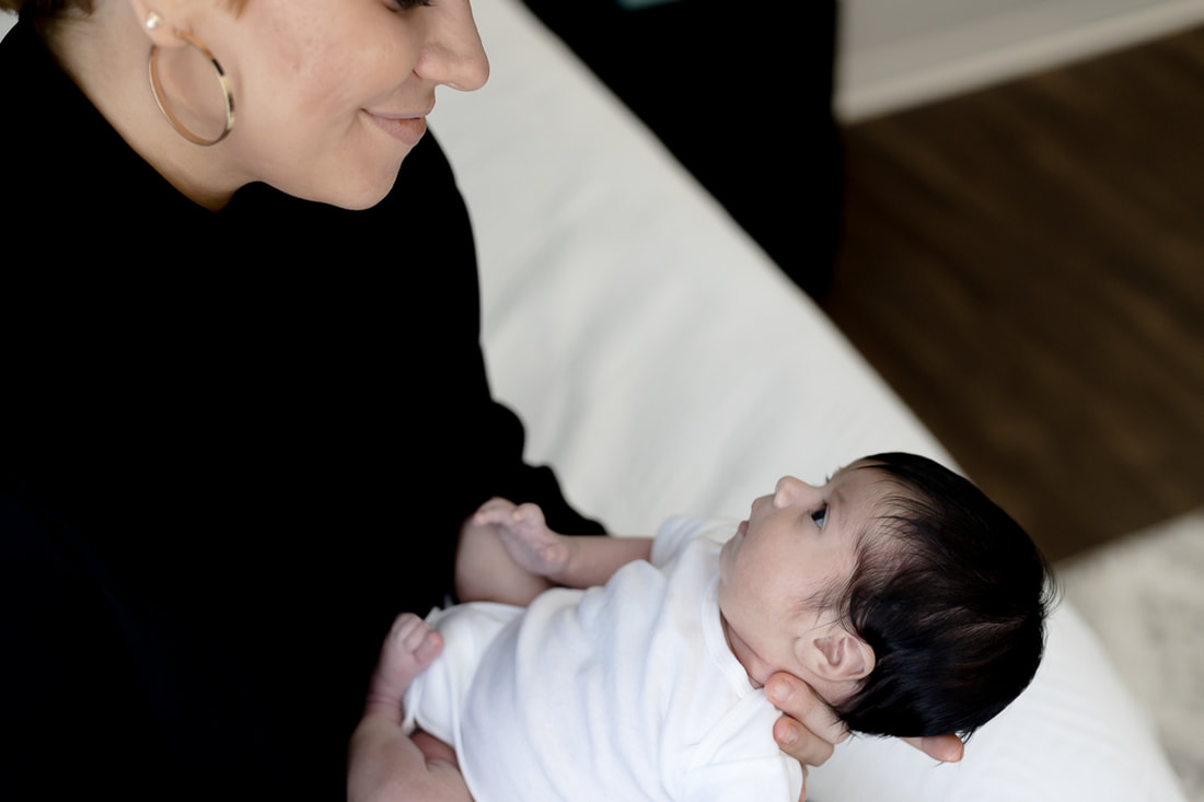 mom holding newborn-looking at her smiling-bradenton-florida