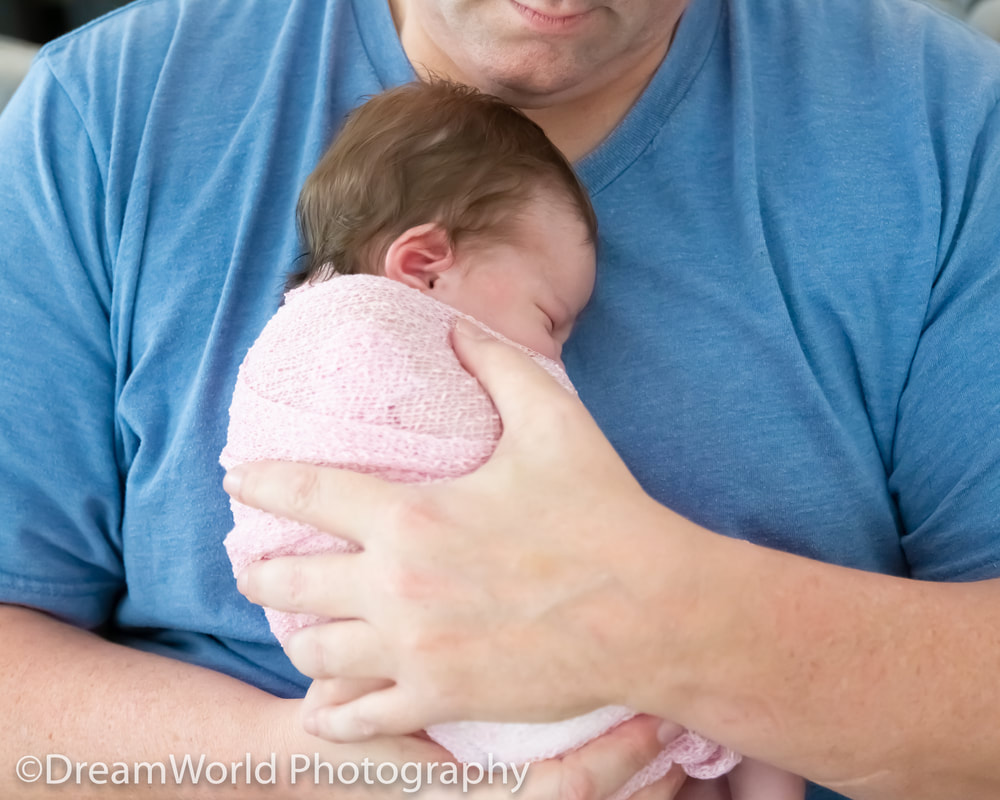 Dad with baby cuddling on chest