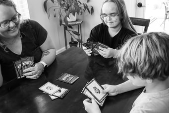 Mom and children around table playing cards