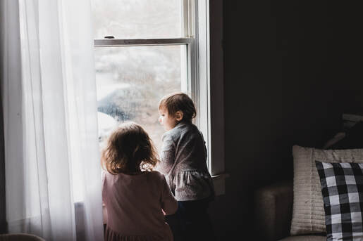 Toddler girls looking out of window