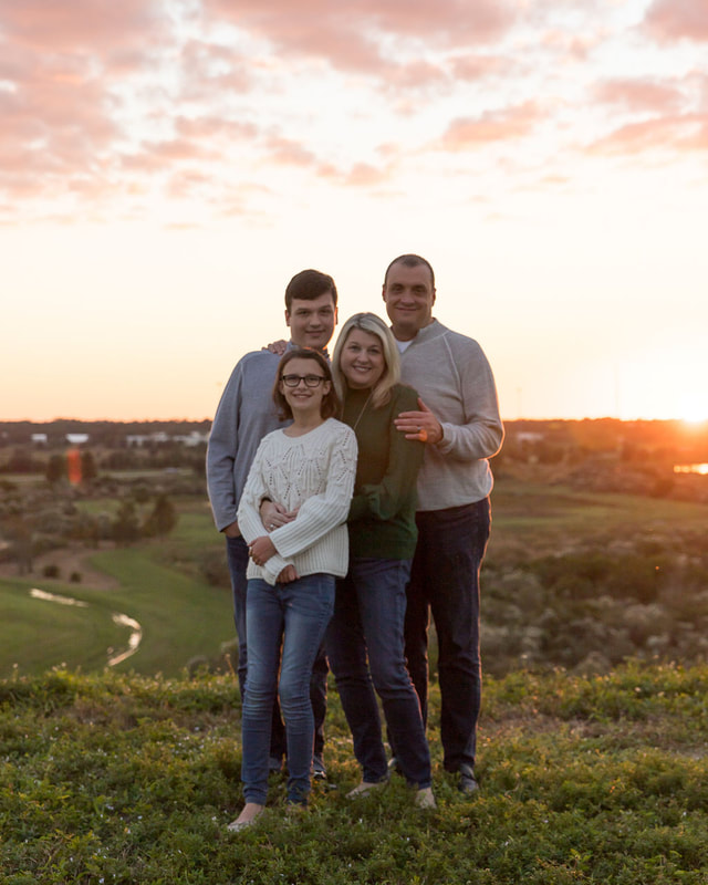 Family of four standing on hill looking at camera, golden hour, Celery Fields, Sarasota, Florida