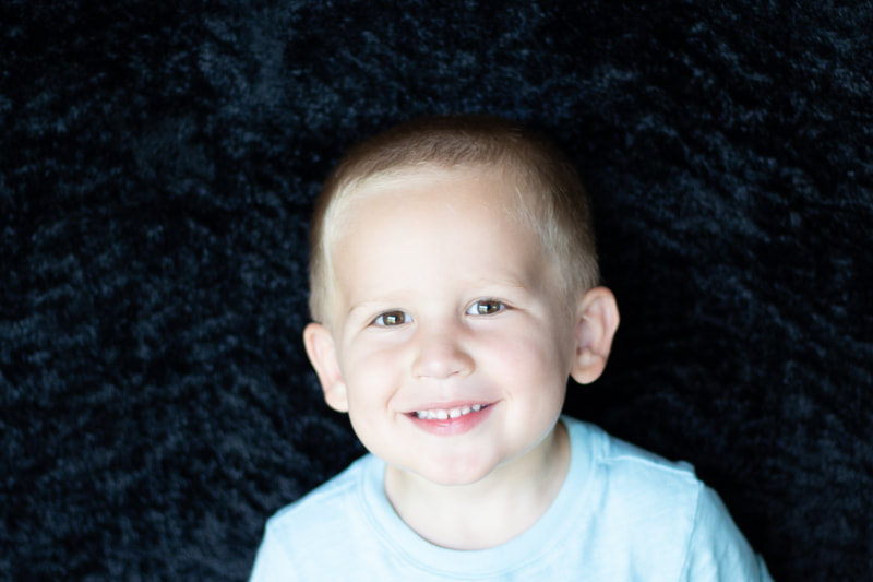 Little boy smiling at camera in color school photo