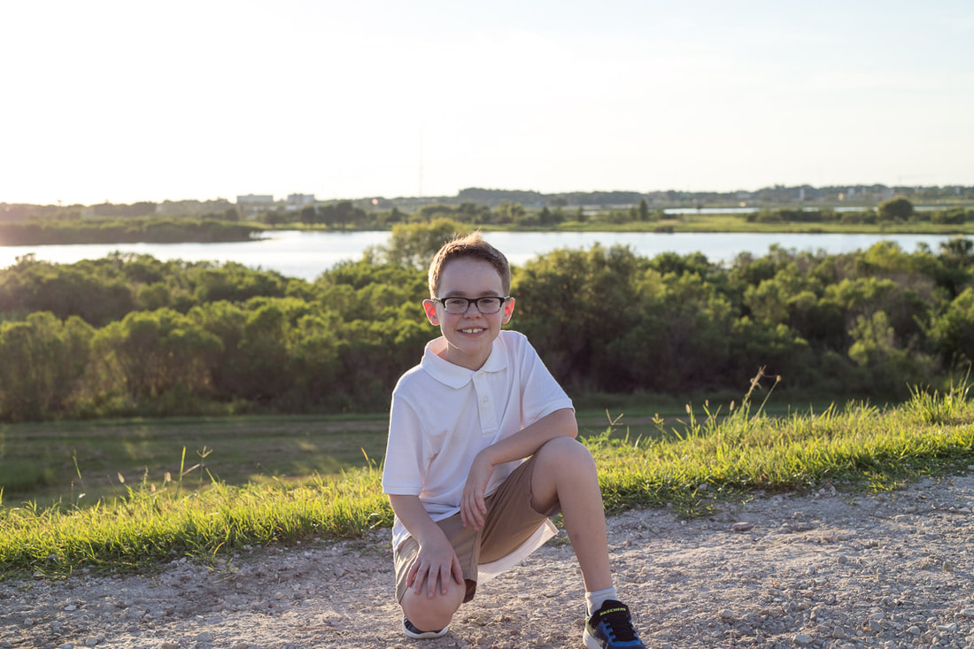 9 year old boy squatting down outside, Celery Fields Sarasota