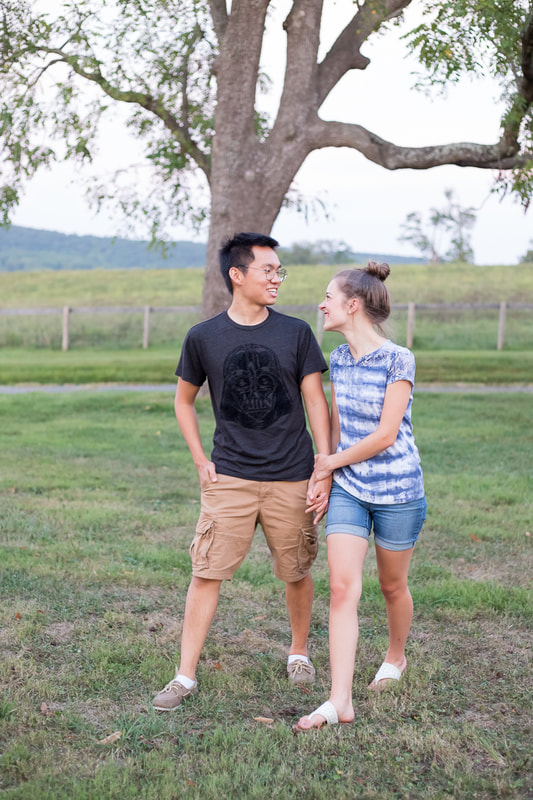 Man and woman walking romantically looking at each other smiling on farm in The Plains, VA