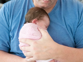 Dad holding baby cuddled on chest