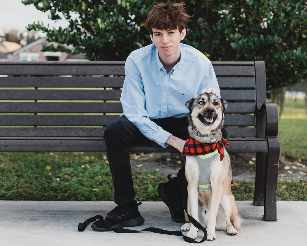 High school senior boy sitting on bench with dog, outdoors, Lakewood Ranch, Florida