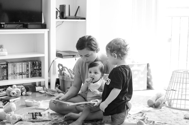 Mom reading a book to children
